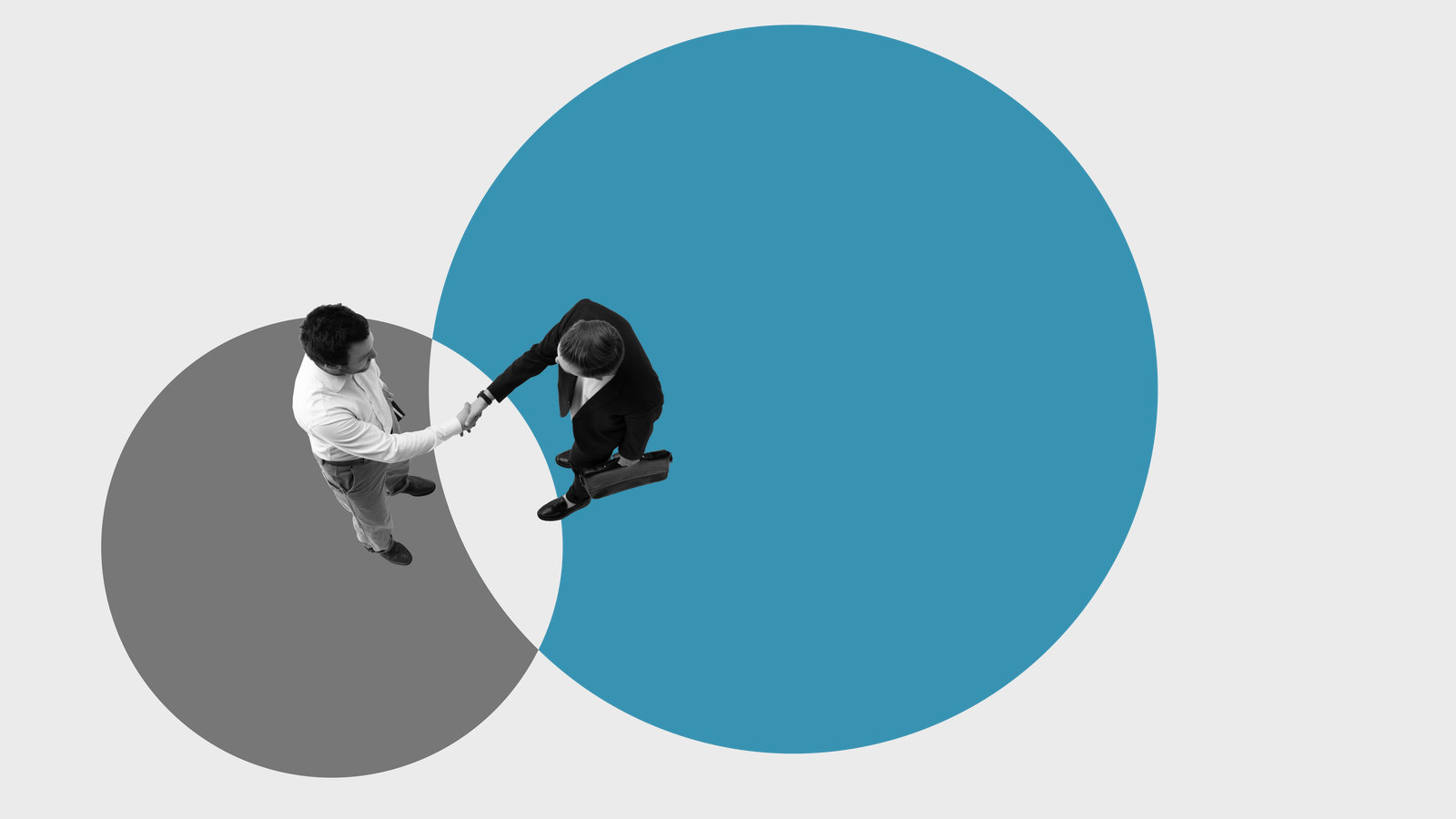 Seen from above, two people shake hands in the overlap
between a small circle and a much larger one.